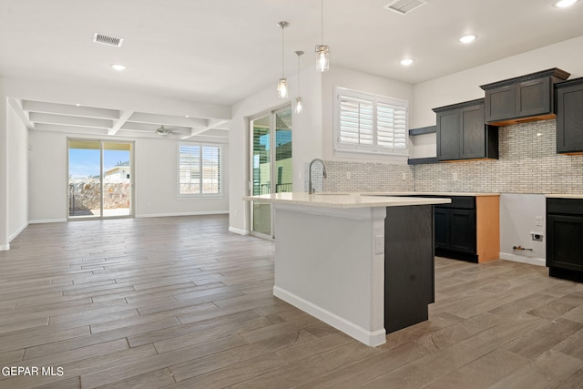 2517 Tony Harper St, El Paso, TX 79938 - kitchen with hanging light fixtures, ceiling fan, backsplash, coffered ceiling, and light hardwood / wood-style floors