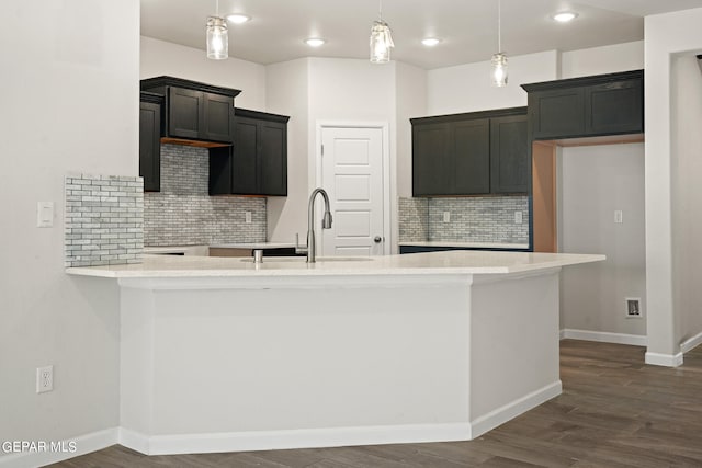 2517 Tony Harper St, El Paso, TX 79938 - kitchen with decorative light fixtures, backsplash, dark wood-type flooring, sink, and light stone counters
