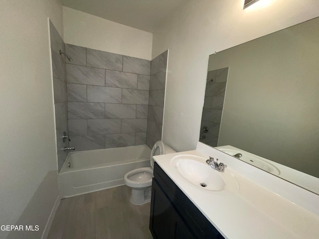 full bathroom featuring hardwood / wood-style floors, vanity with extensive cabinet space, toilet, and tiled shower / bath