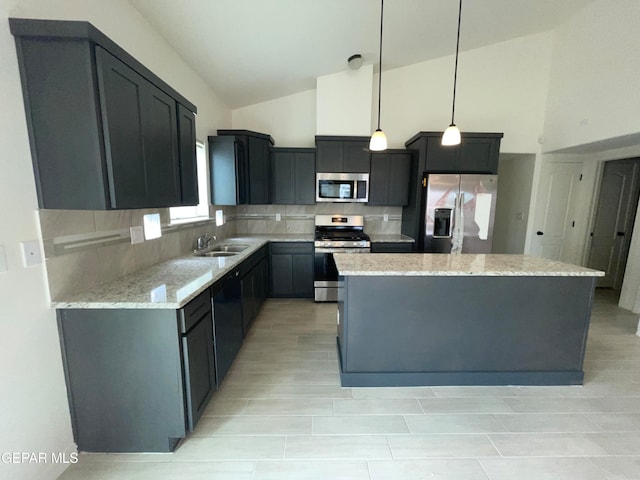 kitchen featuring backsplash, a kitchen island, decorative light fixtures, and appliances with stainless steel finishes