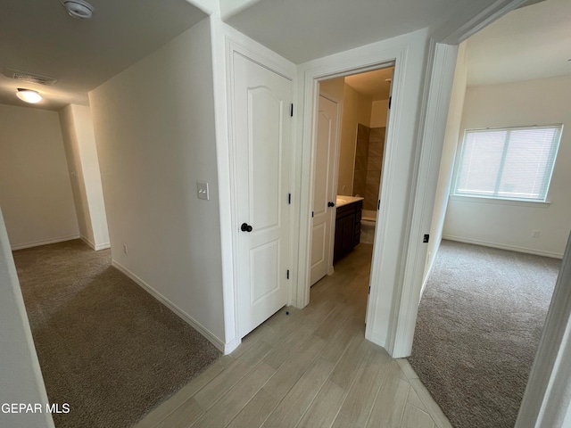 hall with light colored carpet