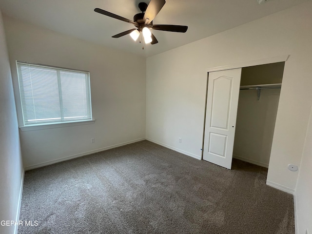 unfurnished bedroom with ceiling fan, dark colored carpet, and a closet