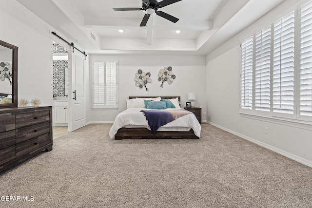 carpeted bedroom with a barn door and ceiling fan