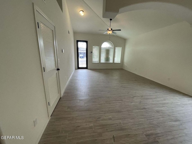 empty room featuring lofted ceiling, ceiling fan, and dark hardwood / wood-style flooring