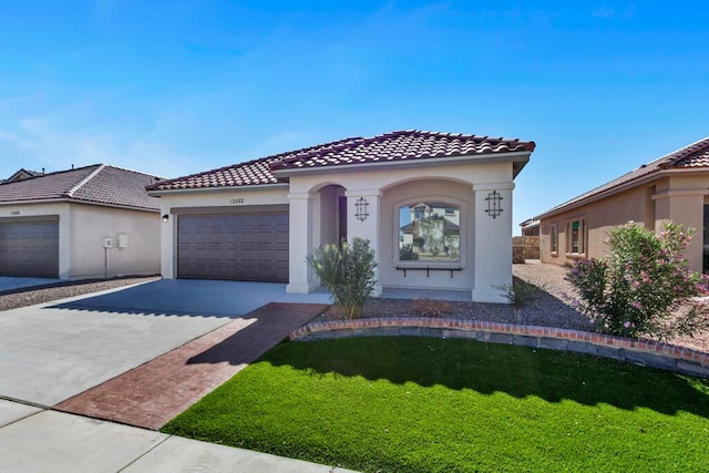 mediterranean / spanish house featuring a front yard and a garage