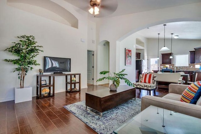 living room featuring lofted ceiling, dark hardwood / wood-style floors, and ceiling fan