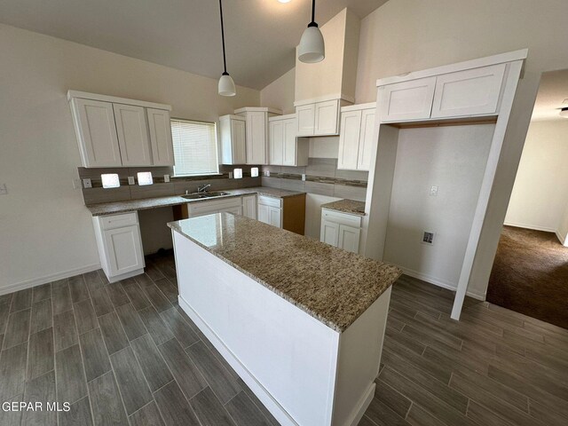 kitchen featuring white cabinetry, dark carpet, and tasteful backsplash