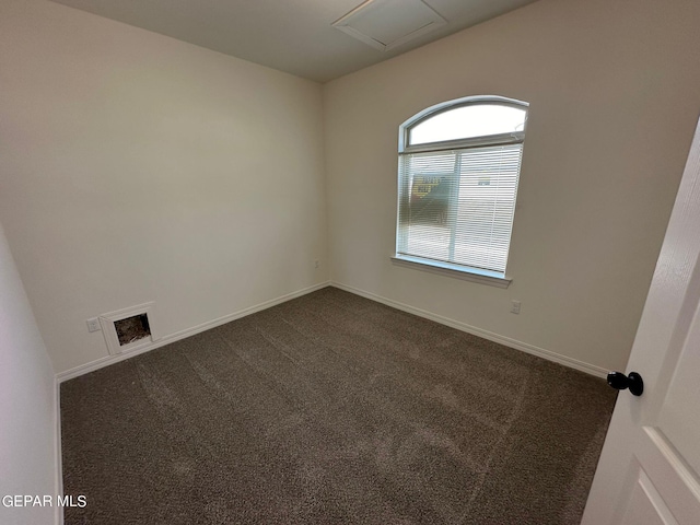 unfurnished room with dark colored carpet