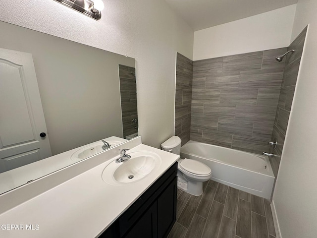 full bathroom with vanity, tiled shower / bath, and toilet