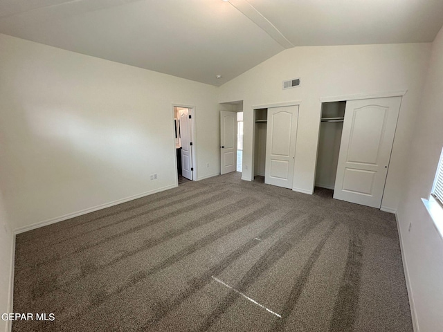 unfurnished bedroom with carpet, a closet, and lofted ceiling