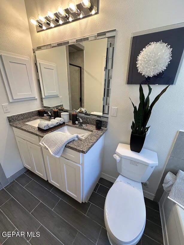 bathroom featuring tile flooring, large vanity, and toilet