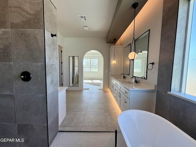 320 Roper Ln, Clint, TX 79836 - full bathroom featuring visible vents, double vanity, tile patterned floors, a soaking tub, and a sink