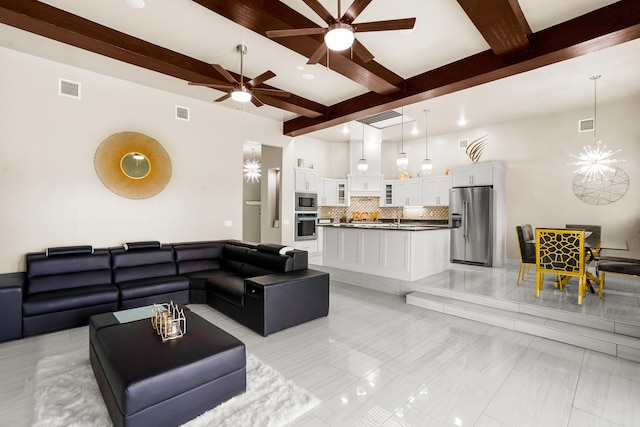 living room with light tile floors, ceiling fan, sink, and beamed ceiling