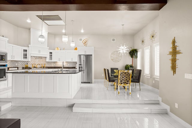 kitchen featuring stainless steel appliances, white cabinets, decorative light fixtures, and light tile floors