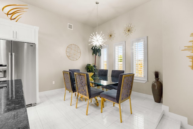 tiled dining room with a high ceiling and a notable chandelier