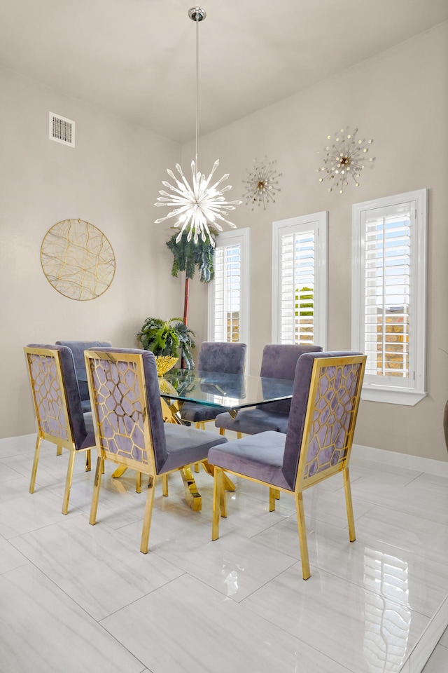 dining space with light tile floors, a chandelier, and a high ceiling