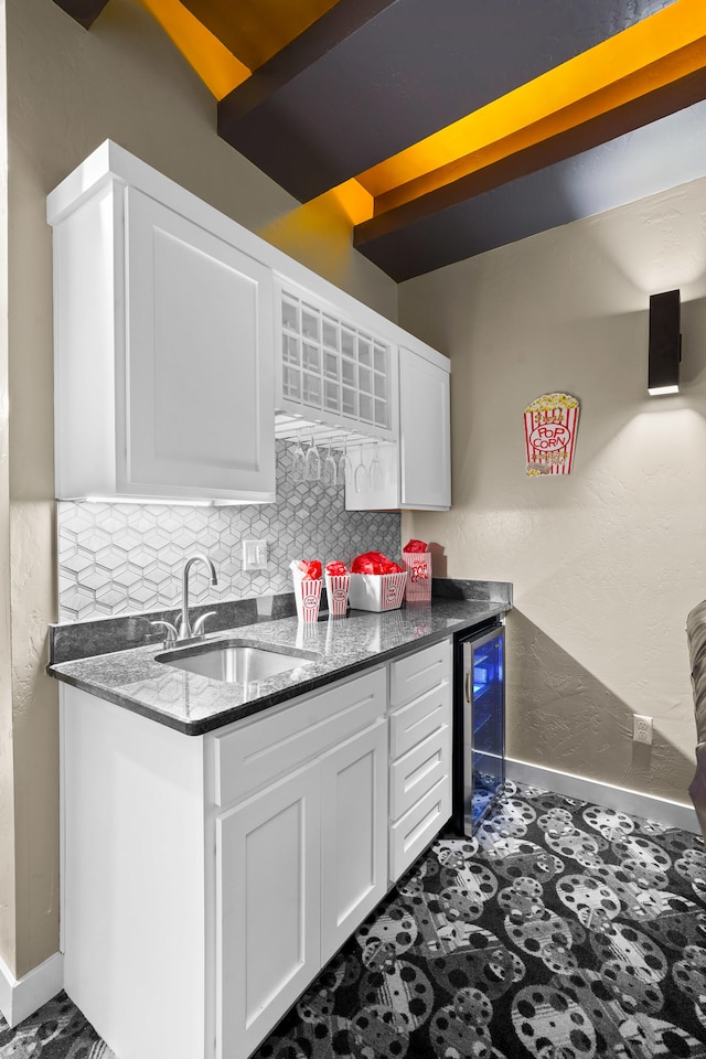 kitchen with white cabinetry, dark tile floors, sink, beverage cooler, and tasteful backsplash