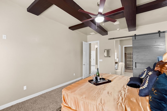 bedroom with carpet, connected bathroom, beam ceiling, a barn door, and ceiling fan