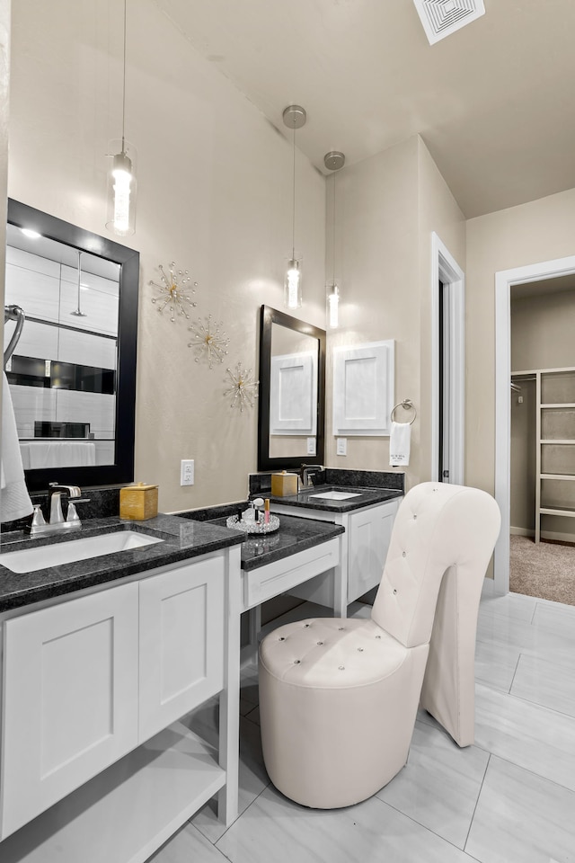 kitchen featuring hanging light fixtures, sink, and white cabinetry