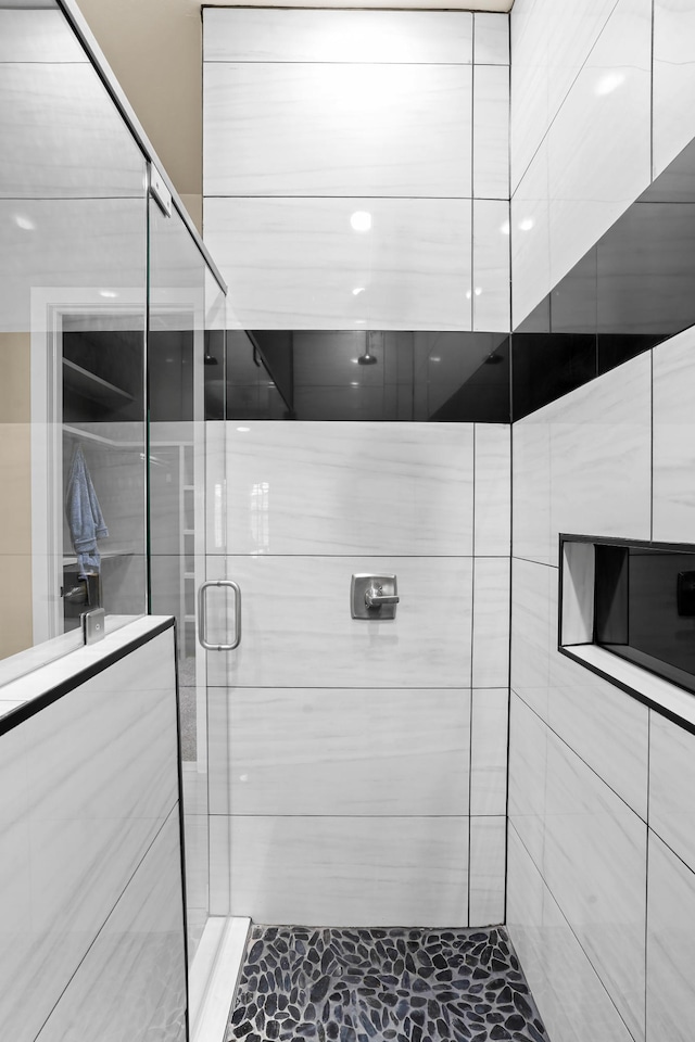 bathroom featuring a shower with door