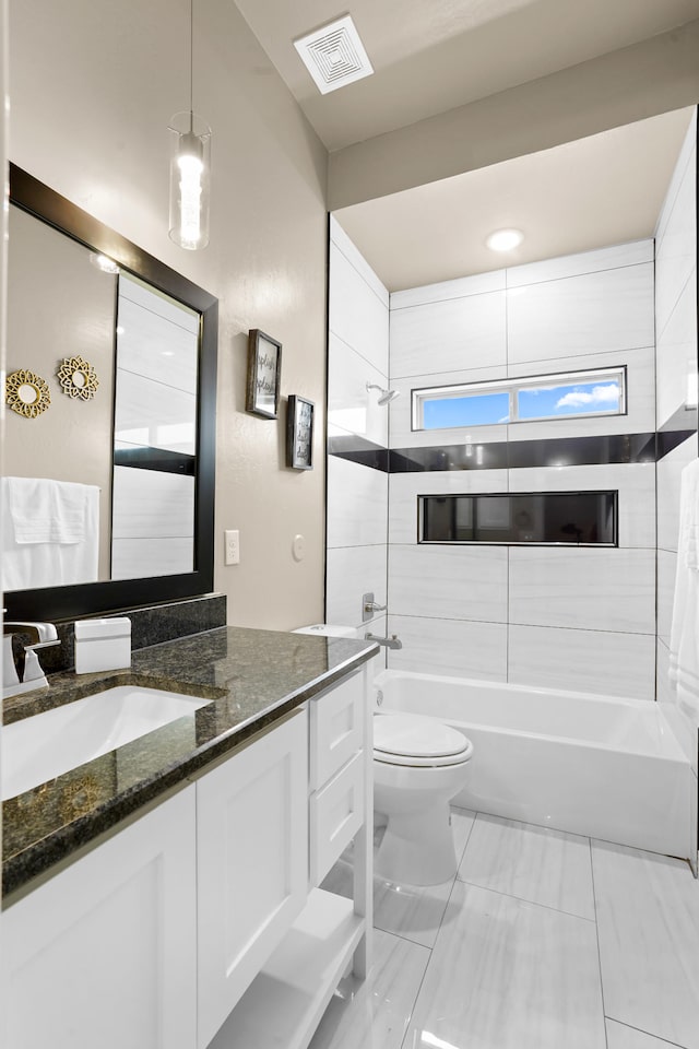 full bathroom featuring tiled shower / bath, toilet, tile flooring, and vanity