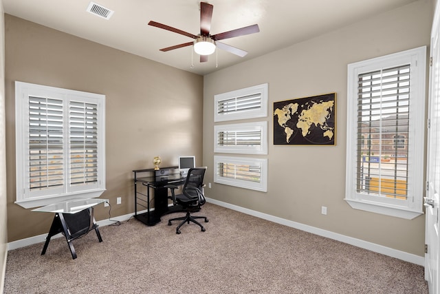 home office featuring light carpet, ceiling fan, and a wealth of natural light