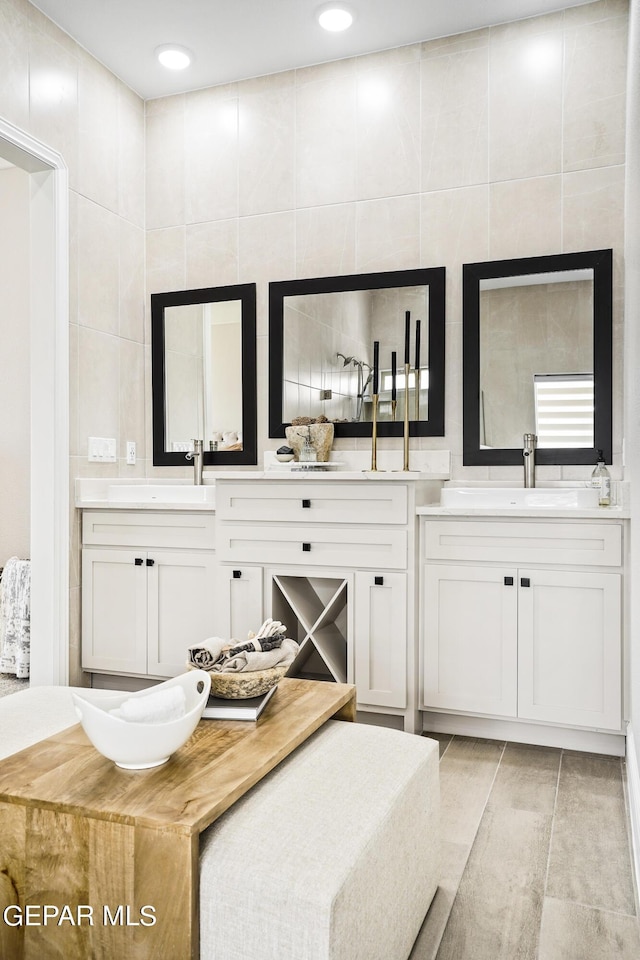 bathroom with vanity, tile patterned floors, and tile walls