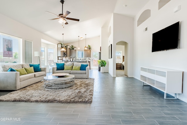 living room featuring a healthy amount of sunlight, dark tile flooring, and ceiling fan