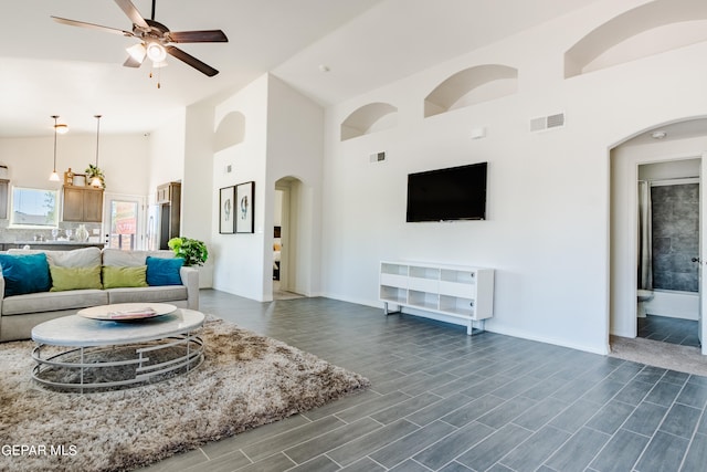 living room with high vaulted ceiling, ceiling fan, and dark hardwood / wood-style flooring