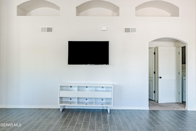 living room featuring dark hardwood / wood-style floors and a high ceiling