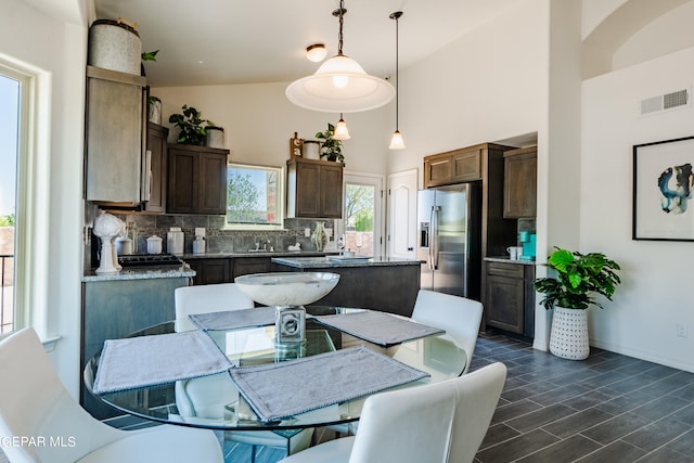 tiled dining room featuring high vaulted ceiling