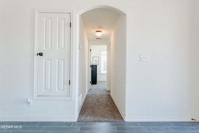 corridor featuring dark colored carpet