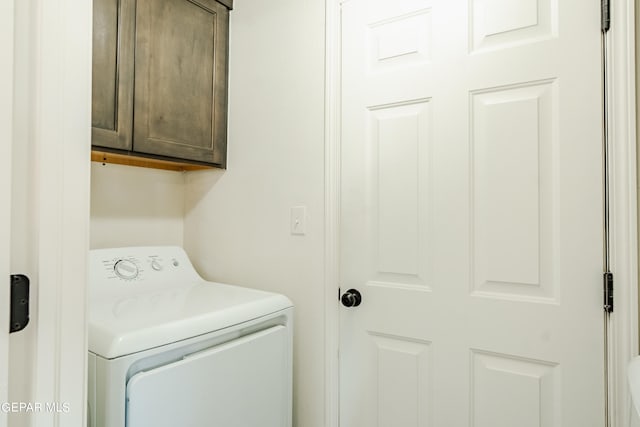 clothes washing area with cabinets and washer / dryer