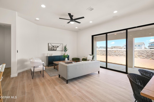 living room with ceiling fan and light wood-type flooring