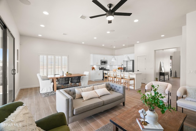 living room featuring ceiling fan and light hardwood / wood-style flooring