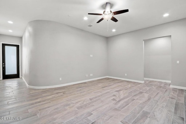 empty room with ceiling fan and light hardwood / wood-style flooring