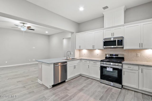 kitchen featuring white cabinets, light stone counters, sink, and stainless steel appliances