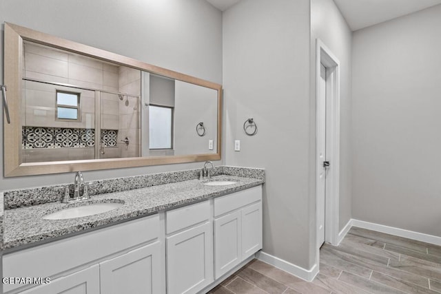 bathroom featuring hardwood / wood-style flooring, vanity, and a shower with shower door