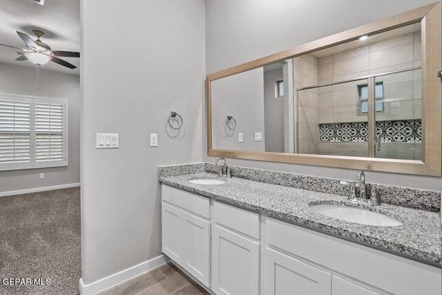 bathroom featuring ceiling fan, vanity, and walk in shower