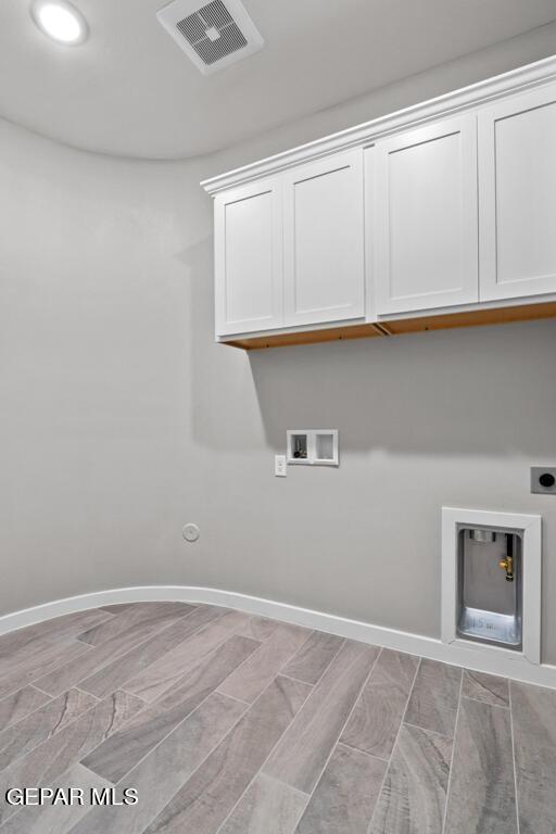 laundry area with cabinets, hookup for a washing machine, light wood-type flooring, gas dryer hookup, and electric dryer hookup