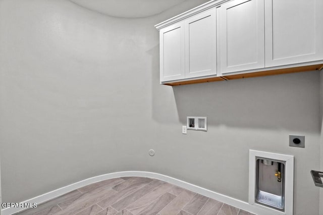 laundry room with cabinets, hookup for an electric dryer, hookup for a gas dryer, hookup for a washing machine, and light hardwood / wood-style floors