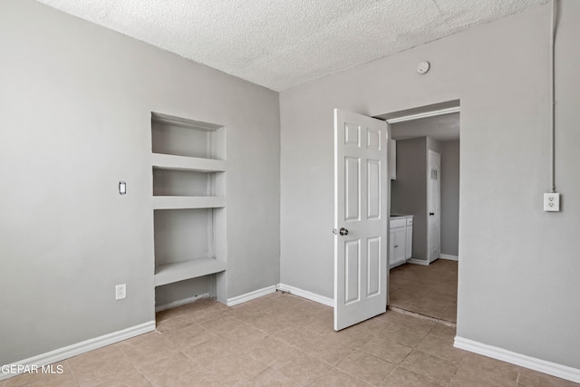 unfurnished bedroom featuring a textured ceiling and light tile flooring