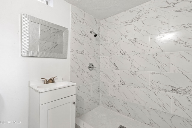 bathroom with oversized vanity and a tile shower