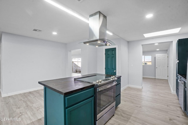 kitchen with stainless steel electric range, island exhaust hood, a skylight, light hardwood / wood-style flooring, and a center island