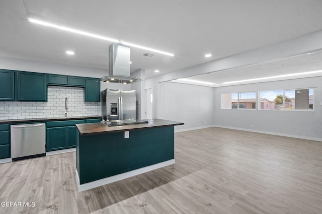 kitchen featuring light hardwood / wood-style floors, a kitchen island, stainless steel appliances, island exhaust hood, and backsplash