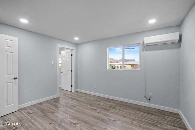 empty room featuring light hardwood / wood-style floors and a wall mounted AC