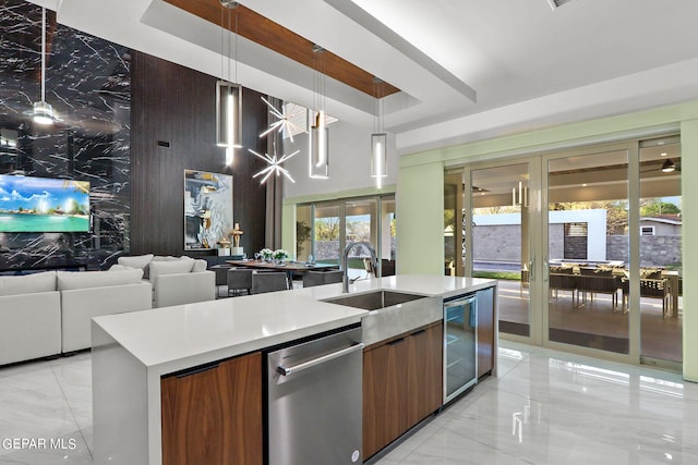 kitchen featuring an island with sink, sink, light tile floors, dishwasher, and decorative light fixtures