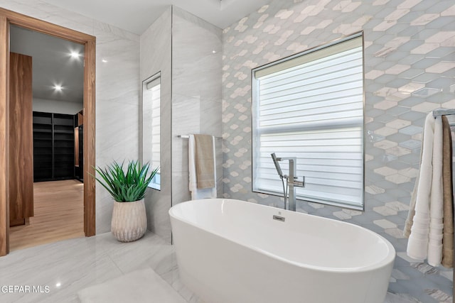 bathroom featuring tile walls, tile floors, and a tub