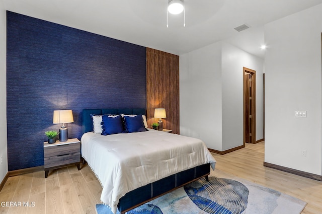 bedroom with ceiling fan and light hardwood / wood-style floors