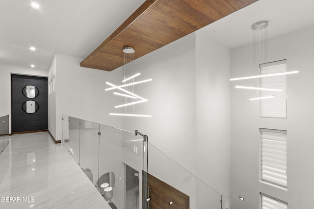 corridor featuring an inviting chandelier, wood ceiling, and light tile flooring